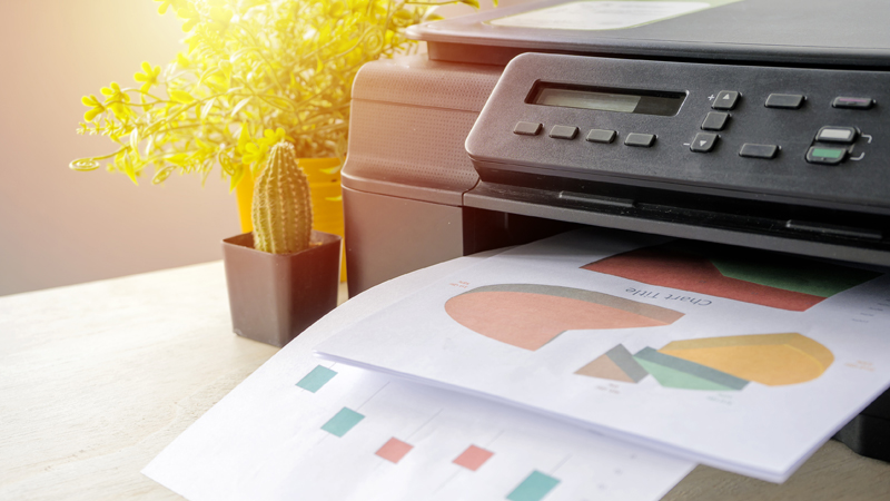 Pormenor de impressora a imprimir folhas com gráficos coloridos